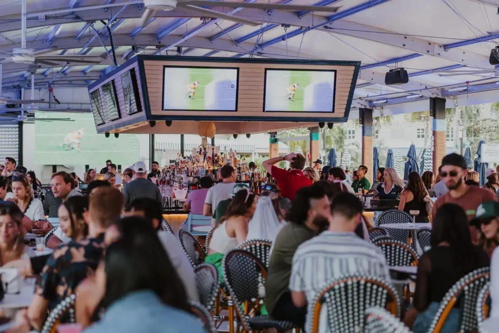 People drinking at tables and at the bar of The Wharf Fort Lauderdale