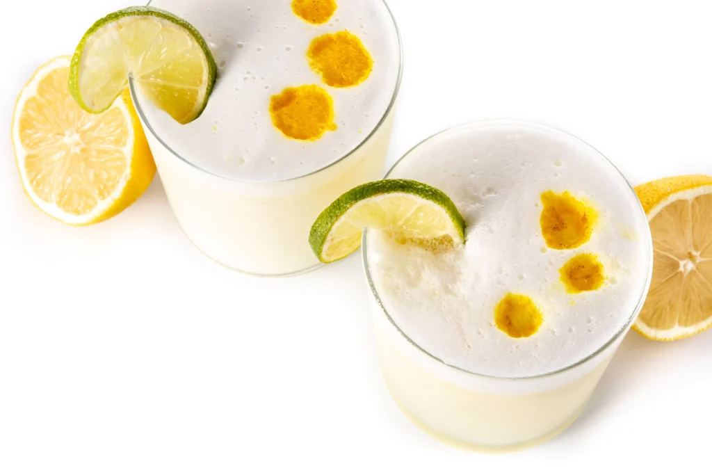 Pisco sour cocktail isolated white with traditional peruvian cocktail